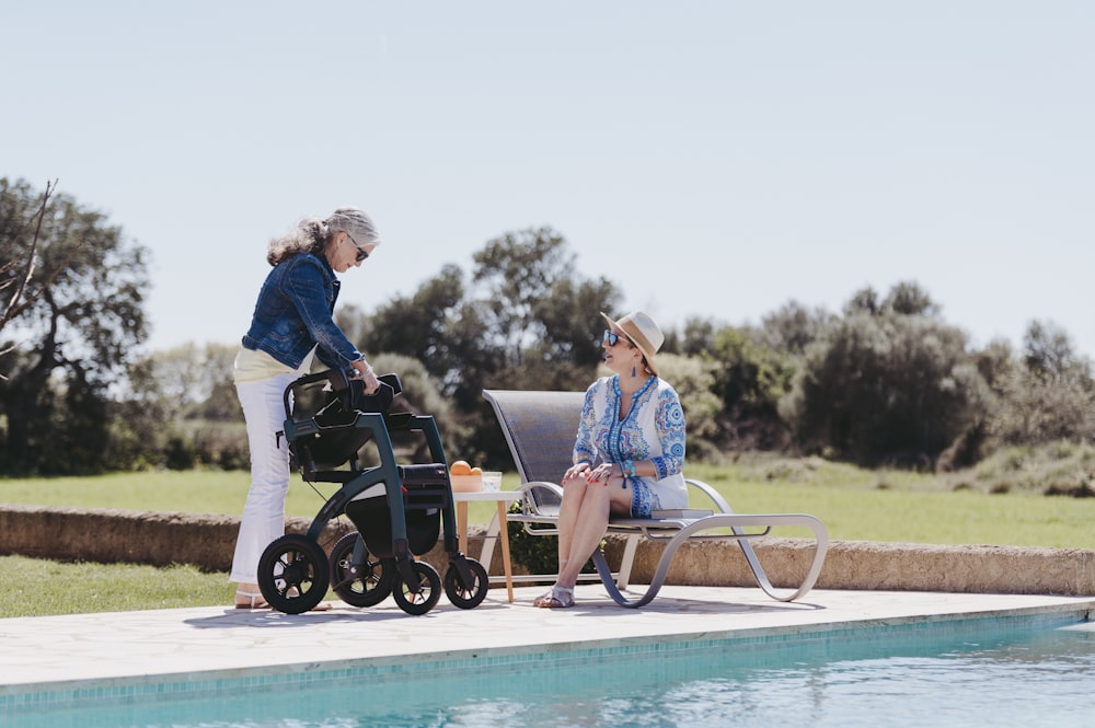 a woman pushing a stroller next to a pool
