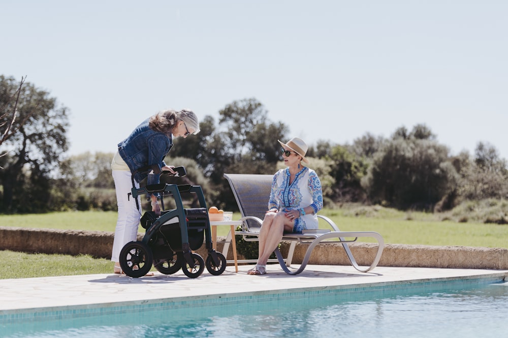 a woman sitting in a chair next to a pool