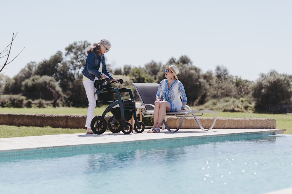 a woman pushing a walker next to a pool
