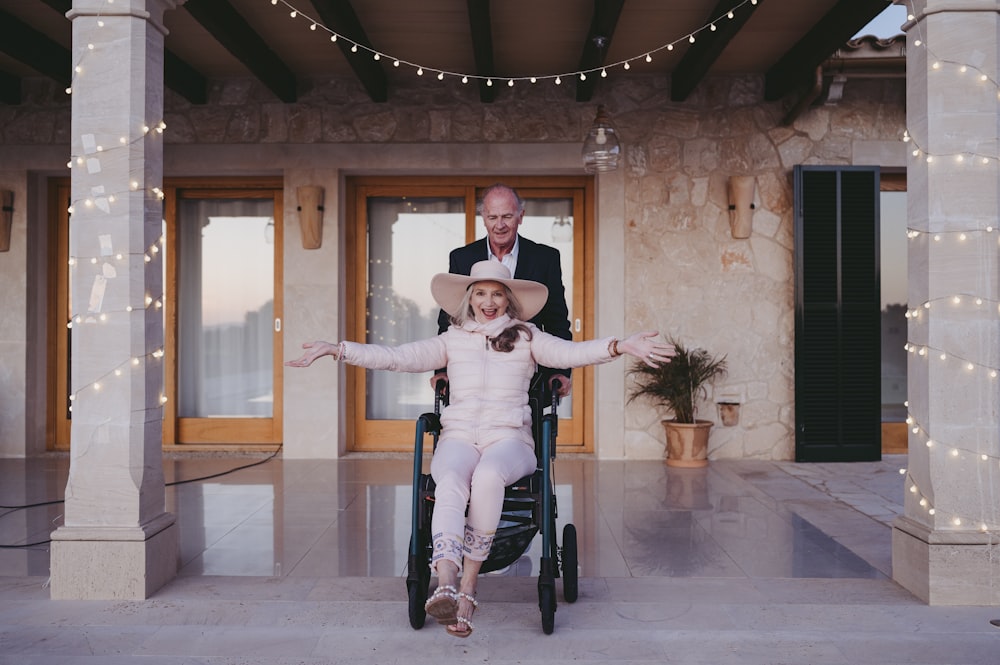 a man standing next to a little girl in a chair