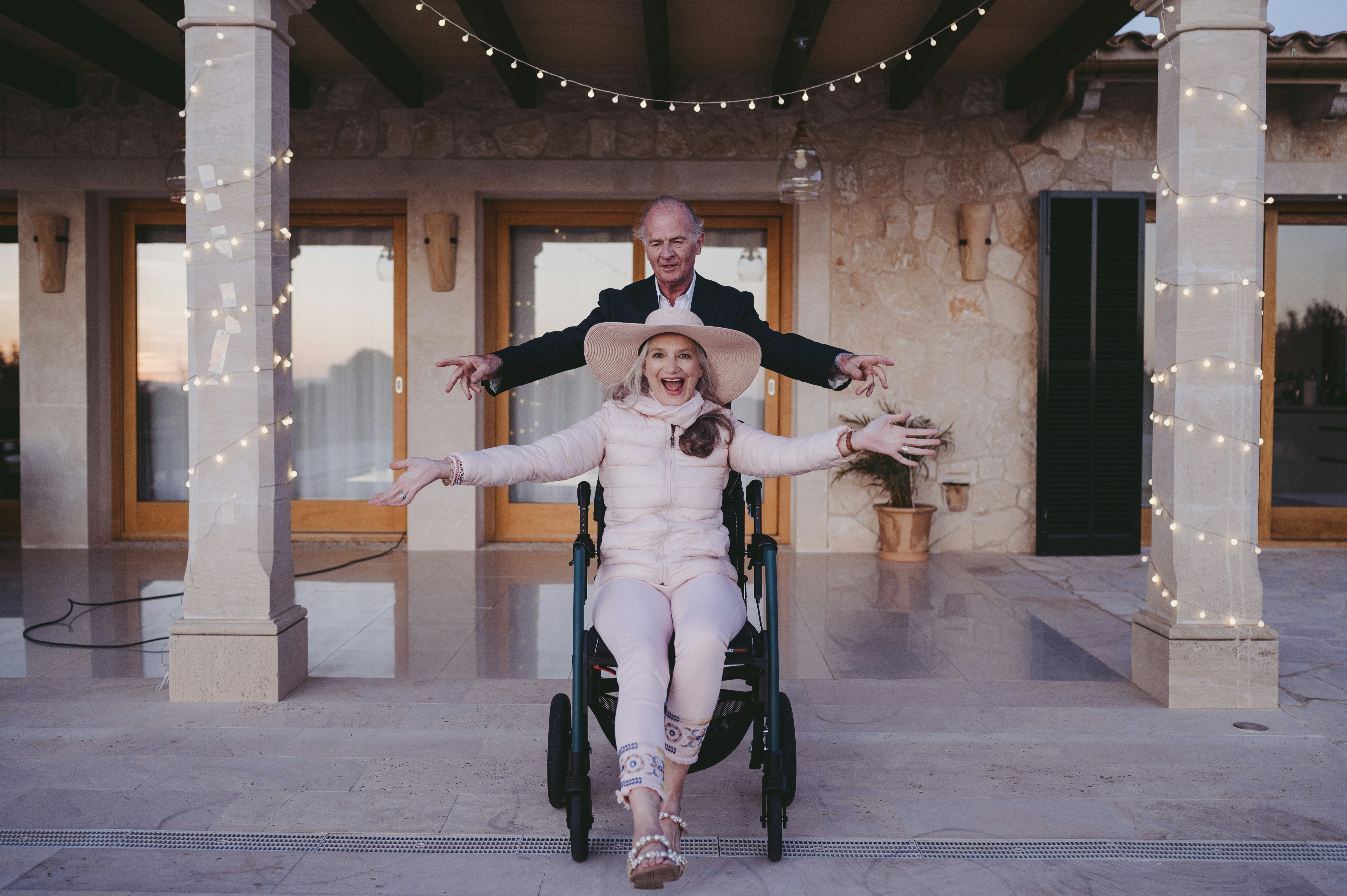 a woman in a wheelchair with a man standing behind her