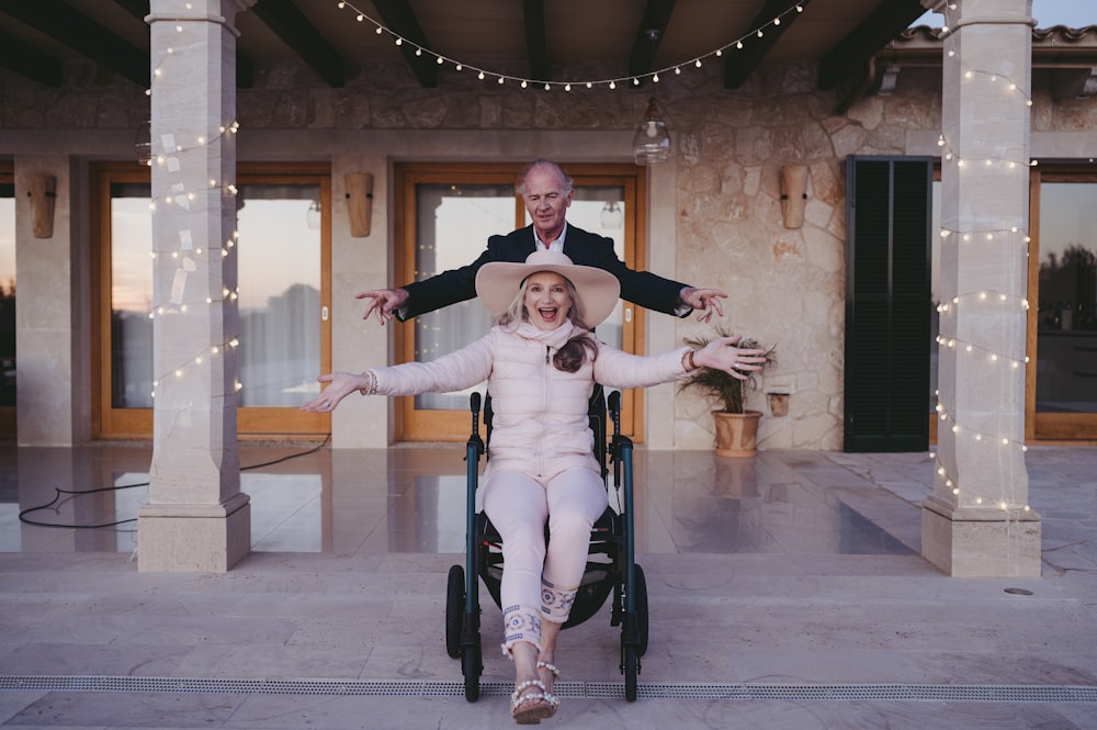 a woman in a wheelchair with a man standing behind her