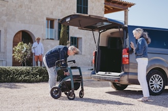 a man pushing a wheelchair next to a van