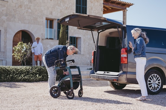 a man pushing a wheelchair next to a van