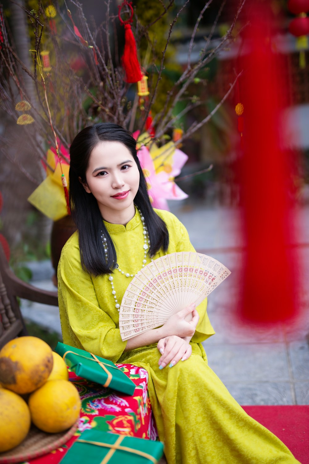 a woman sitting on a bench holding a fan