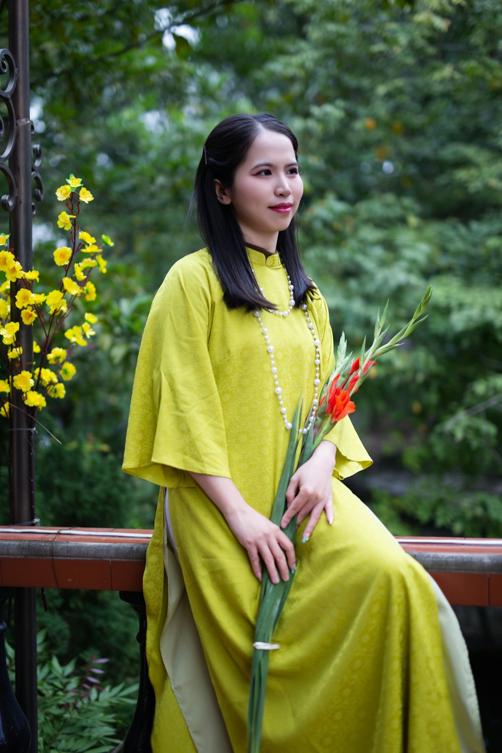 a woman in a yellow dress holding a bouquet of flowers