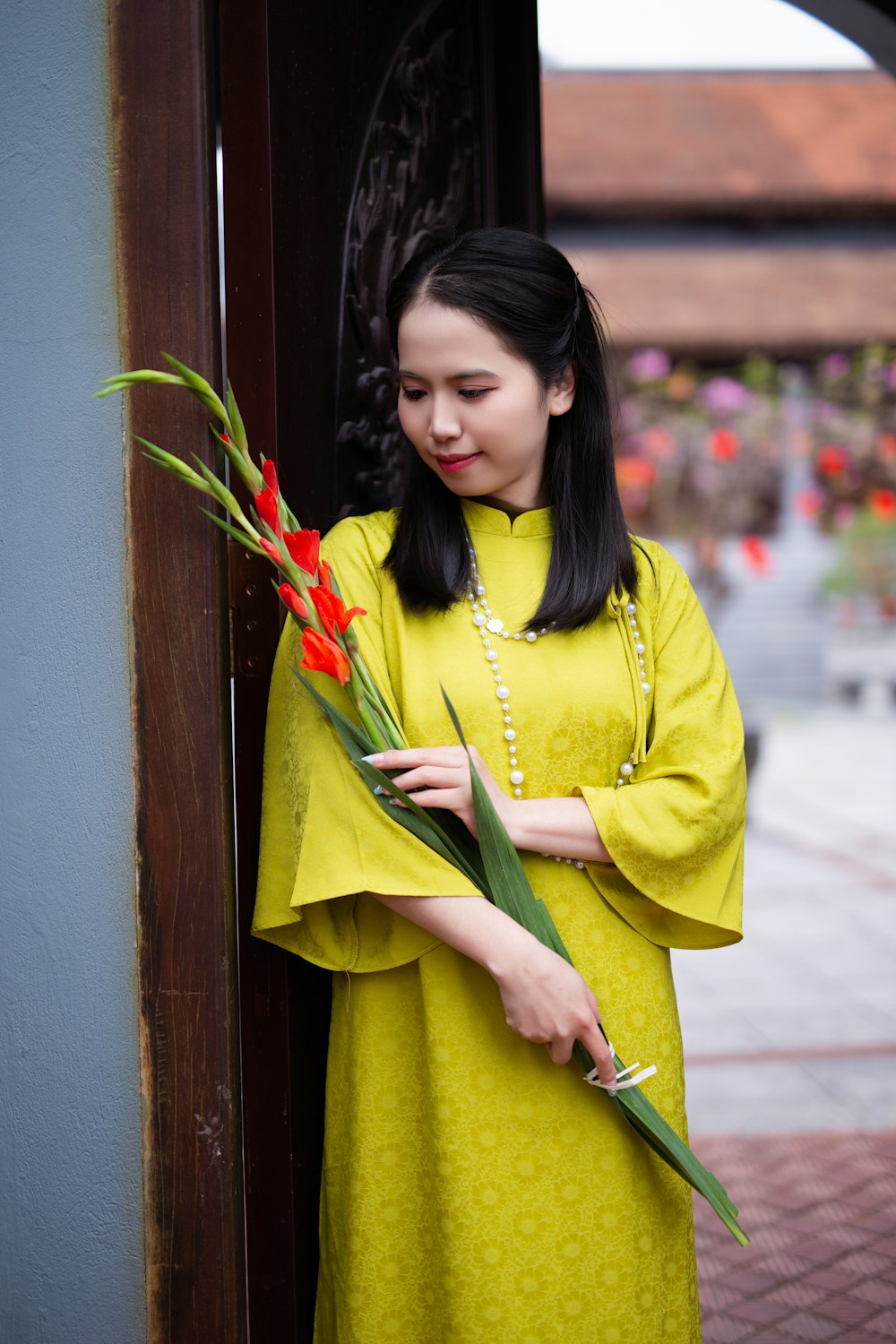 a woman in a yellow dress holding a bouquet of flowers