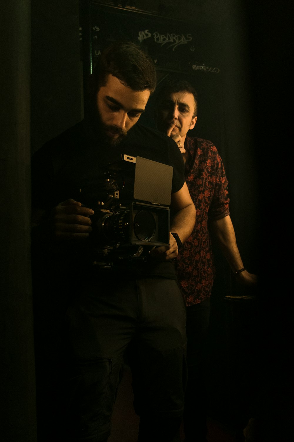 a man standing in front of a mirror holding a camera