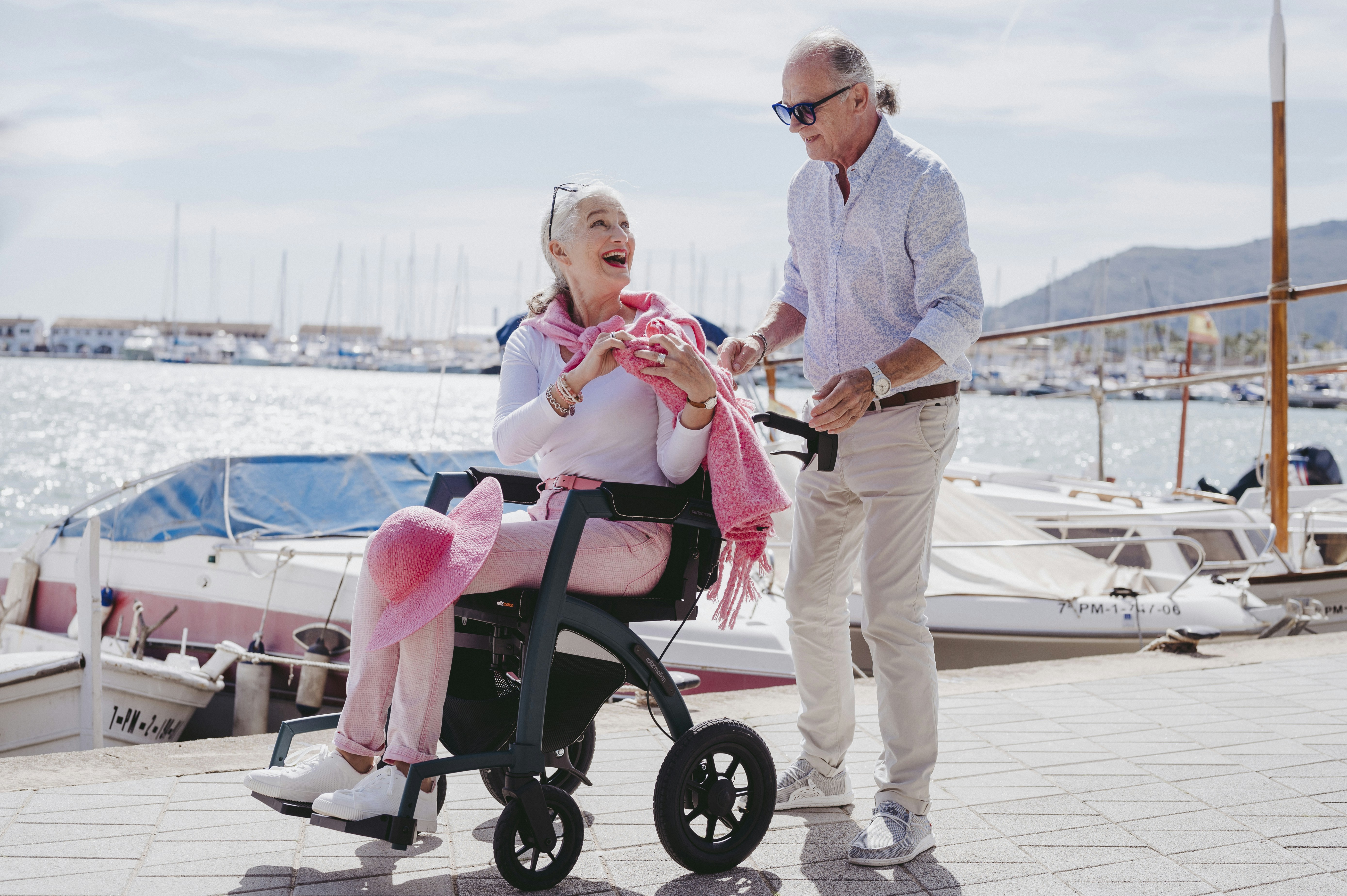 a man standing next to a woman in a wheel chair