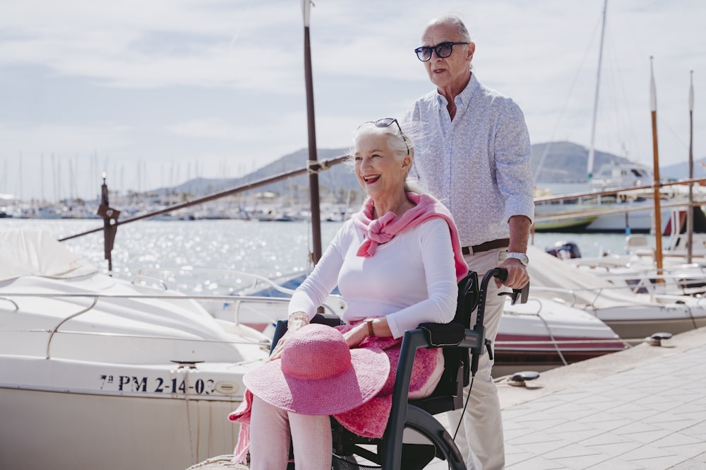 a man standing next to a woman in a wheelchair