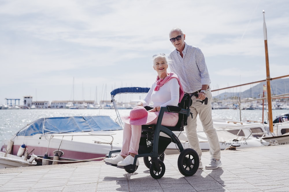 a man standing next to a woman in a wheelchair