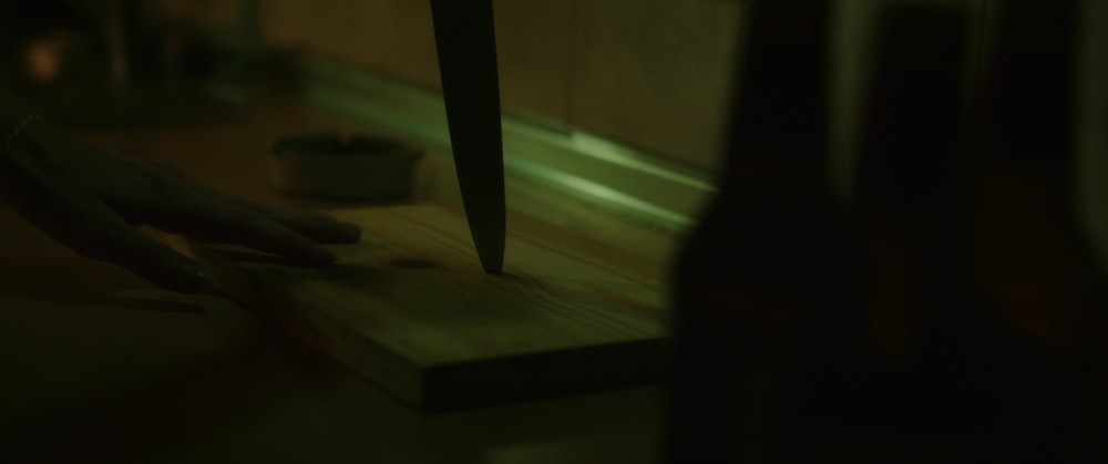 a knife on a cutting board in a dark room