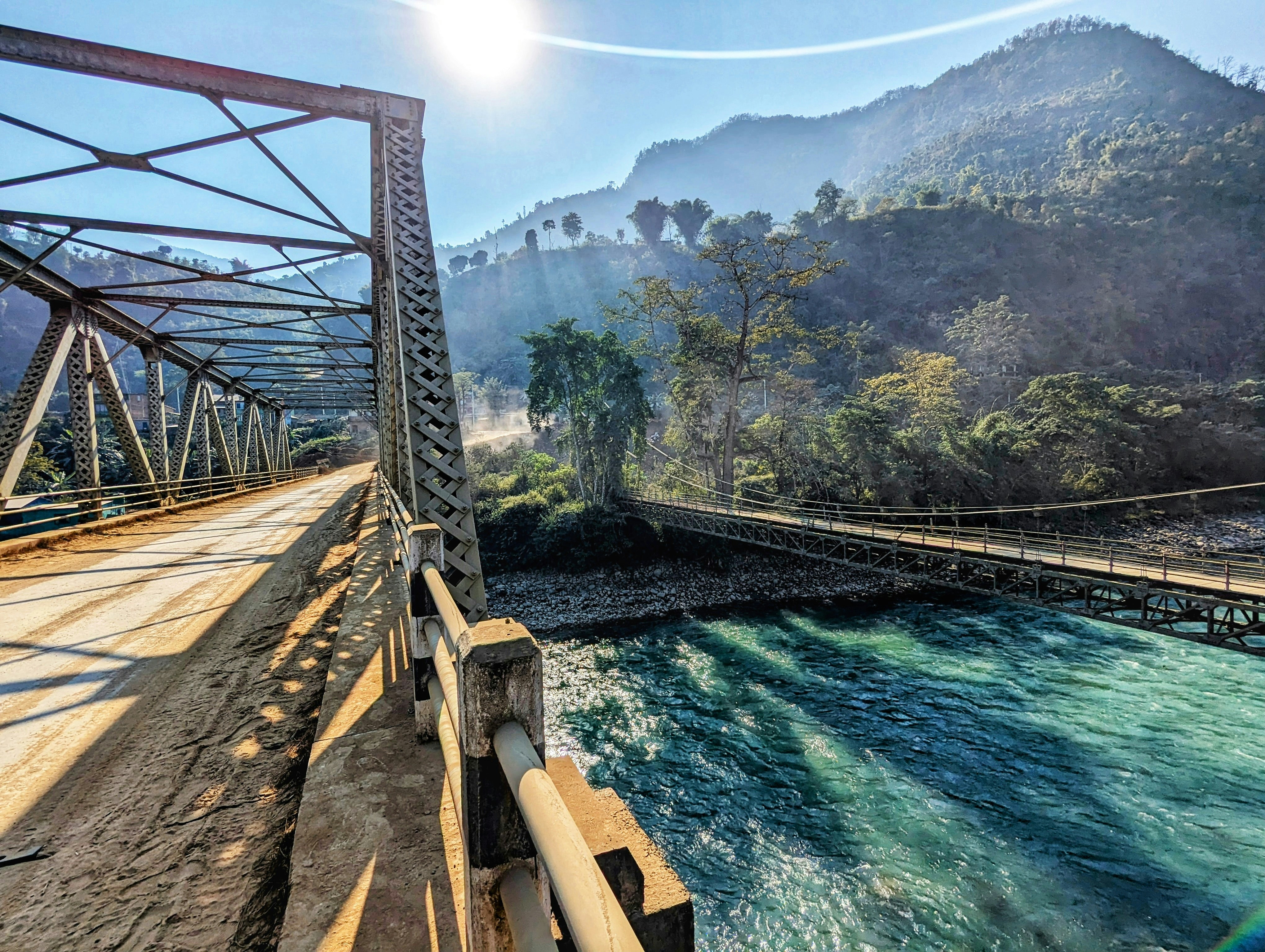 a bridge over a body of water with mountains in the background