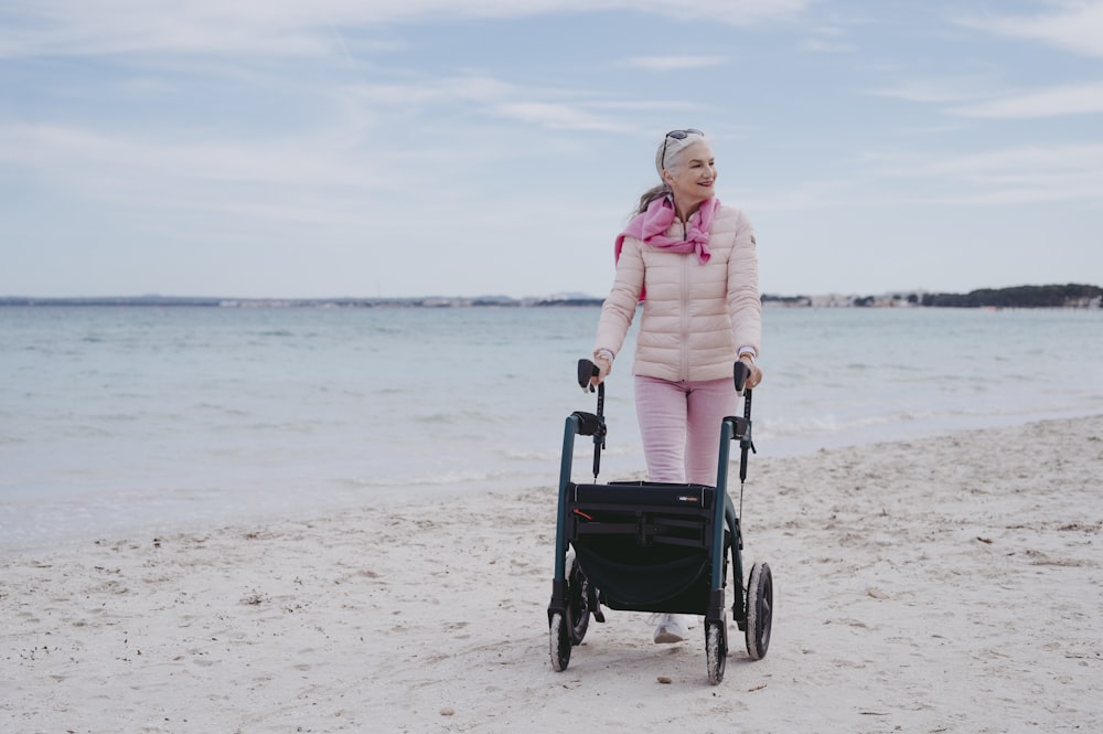 a woman pushing a stroller on the beach