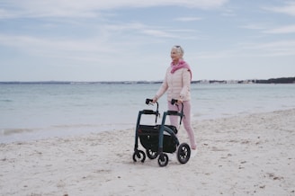 a woman standing on a beach next to a cart