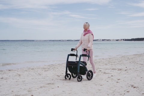 a woman standing on a beach next to a cart