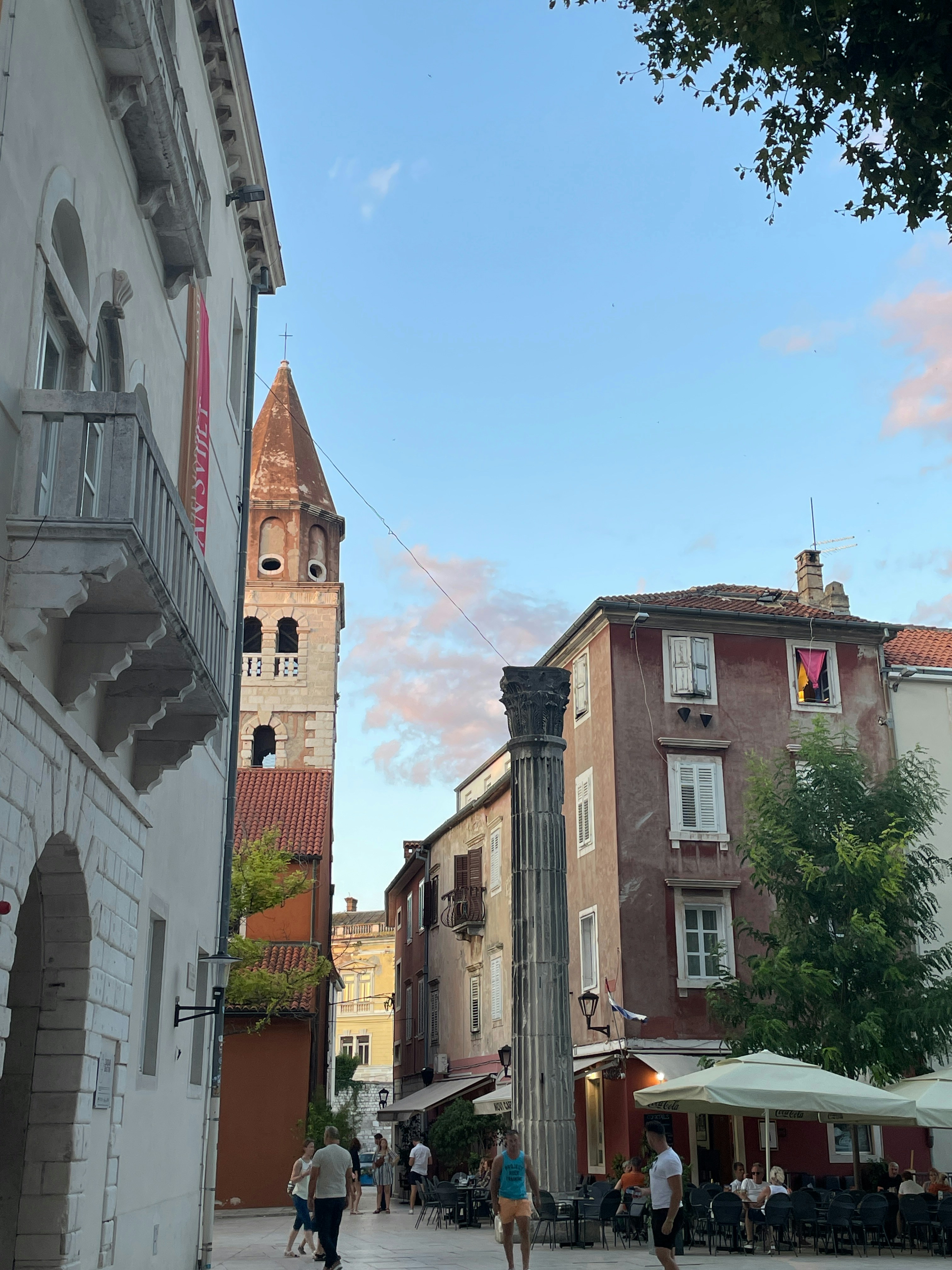 高層ビルの隣の通りを歩いている人々のグループ