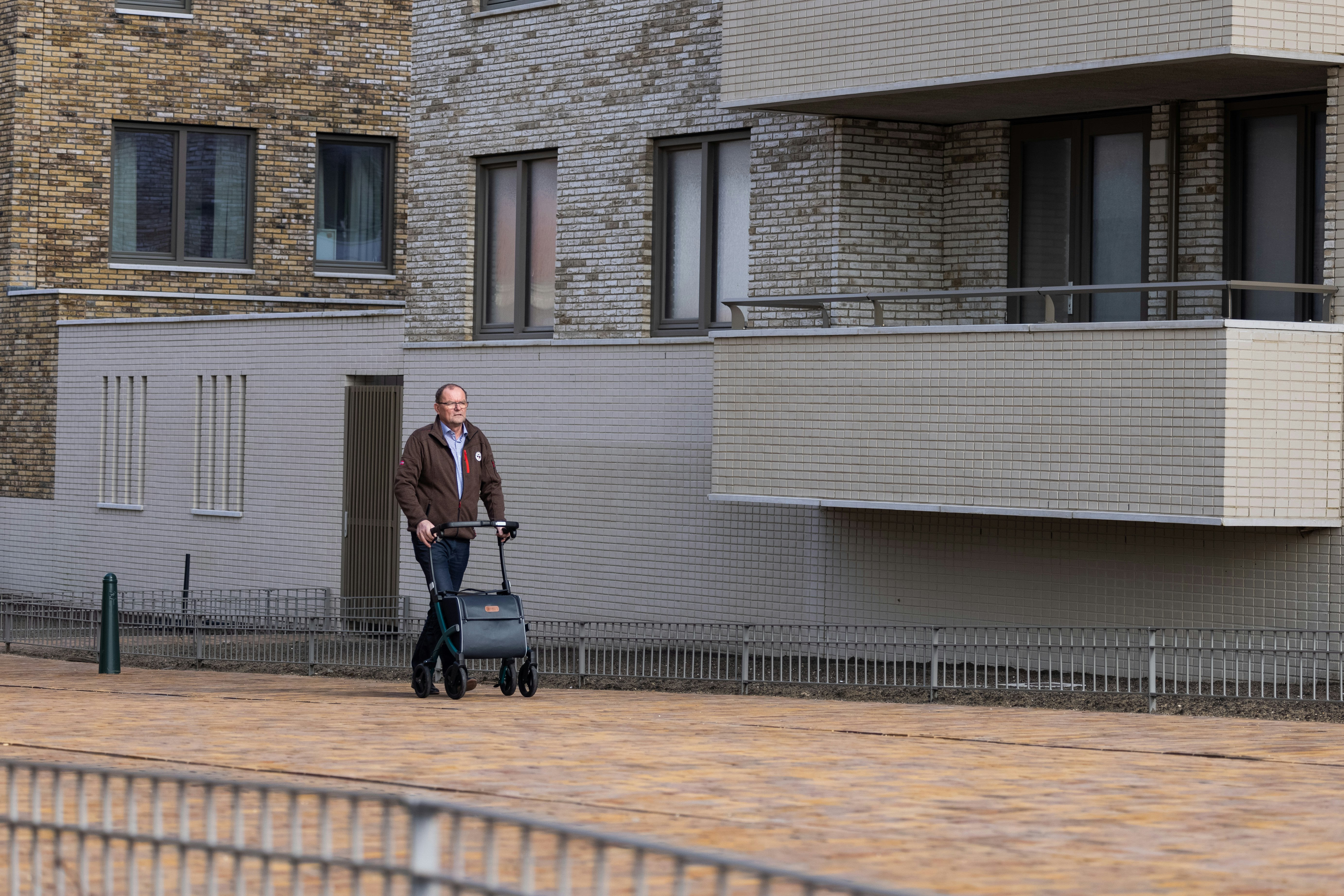 a man pushing a luggage cart down a street