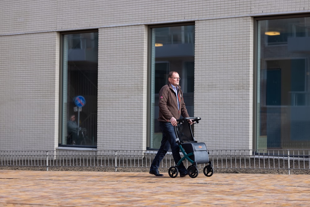 a man pushing a stroller down a sidewalk