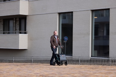 a man riding a scooter next to a tall building