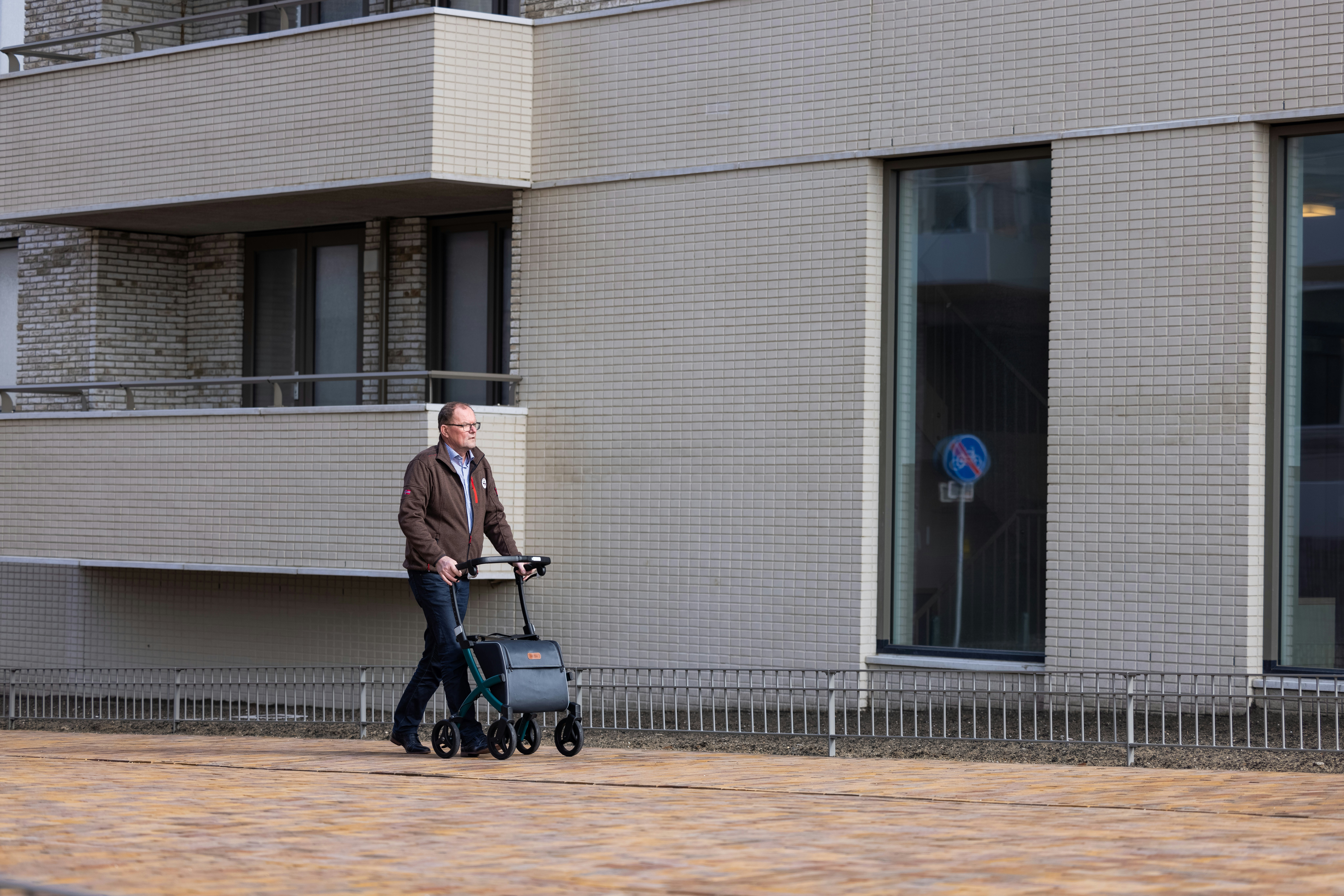 a man pushing a stroller down the street