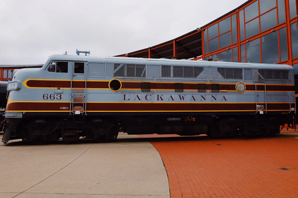 Vintage train engine in white and red colors with yellow accents parked on platform