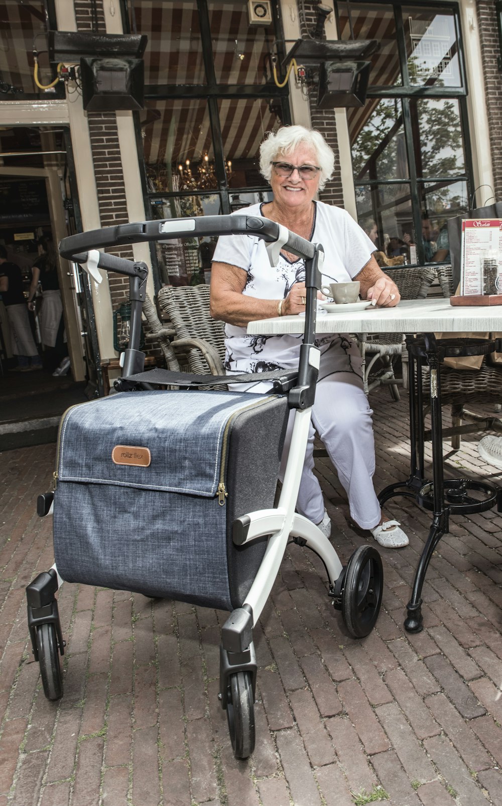 uma mulher sentada em uma mesa com uma mala rolante