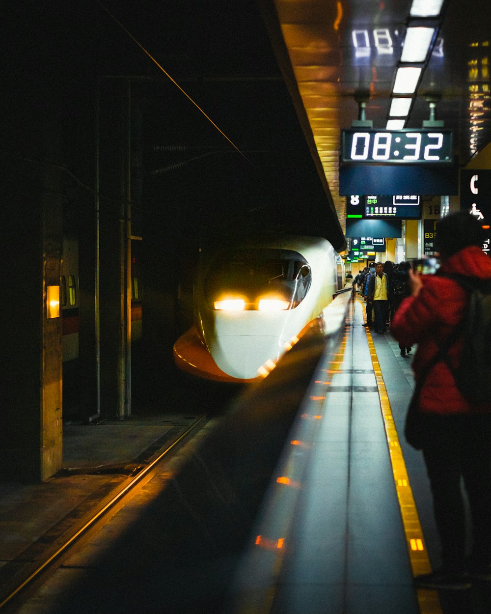 a train pulling into a train station at night