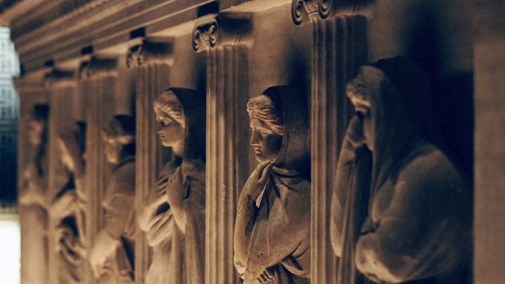 uma fileira de estátuas na lateral de um edifício
