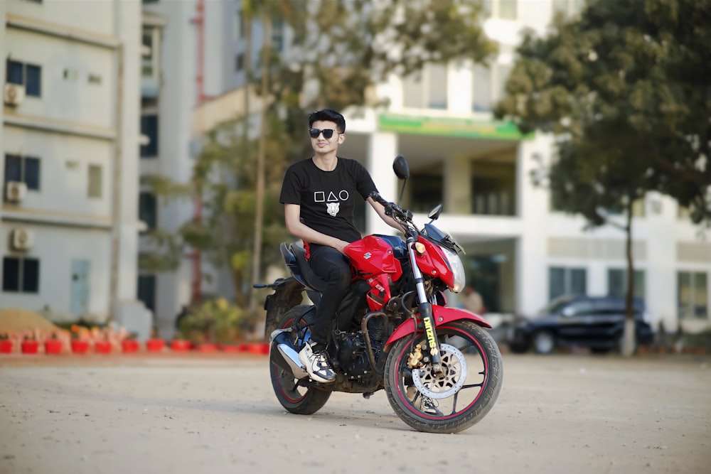 a man is sitting on a red motorcycle