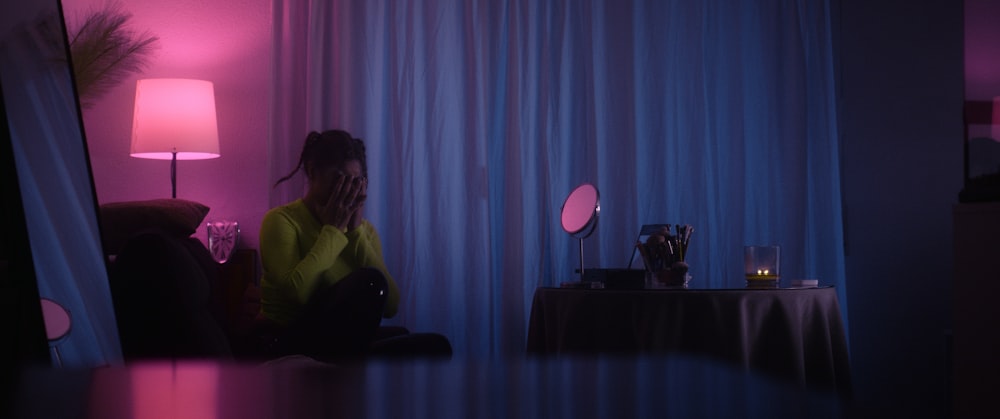 a woman sitting on a couch in a dark room