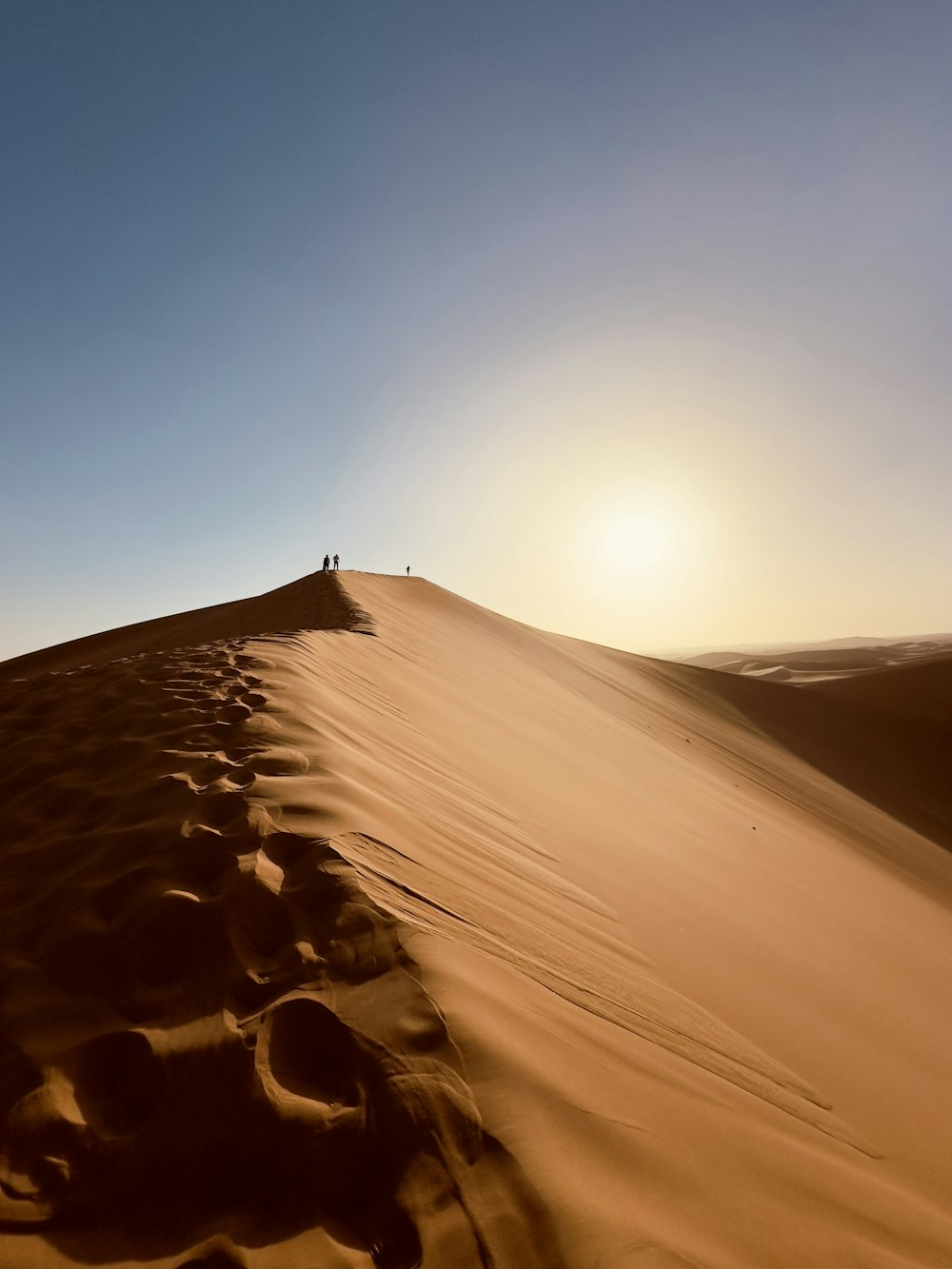 a person standing on top of a sand dune