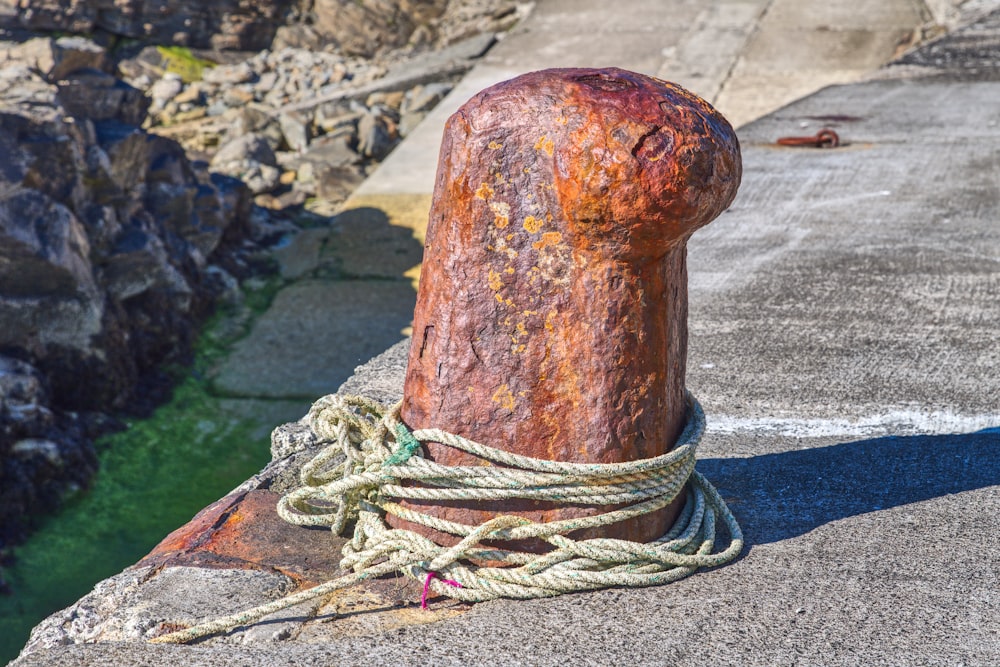 a rope on top of a rock next to a body of water