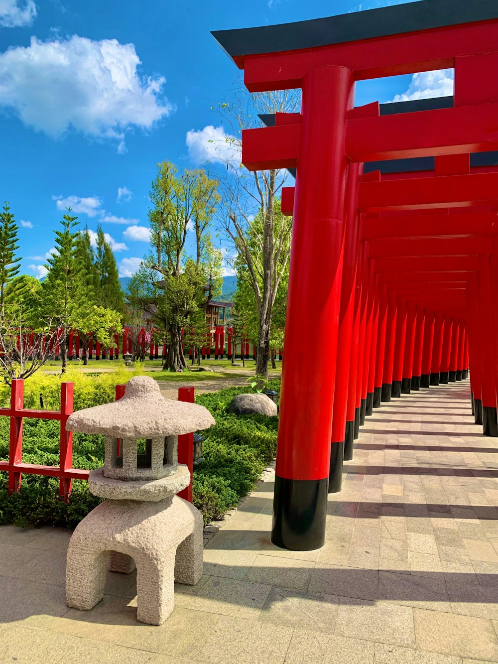 a row of red and black pillars in a park