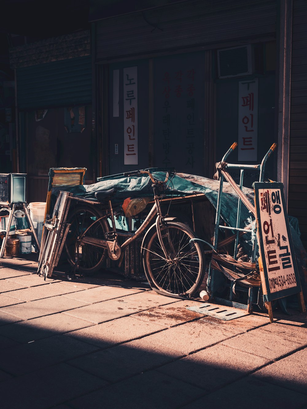 a bicycle parked next to a pile of junk