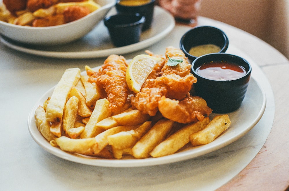 a white plate topped with fries and dipping sauce