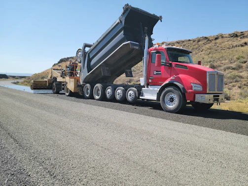 a red dump truck driving down a road