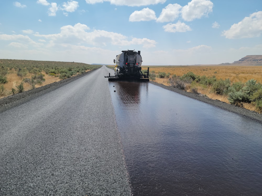 a large truck driving down a wet road
