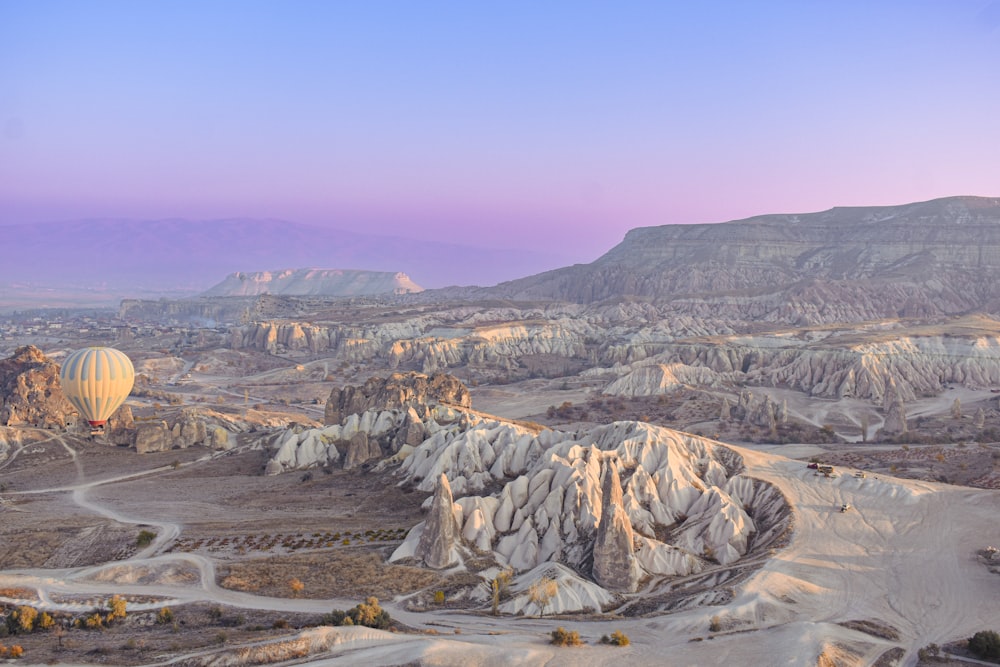 a hot air balloon flying over a desert landscape