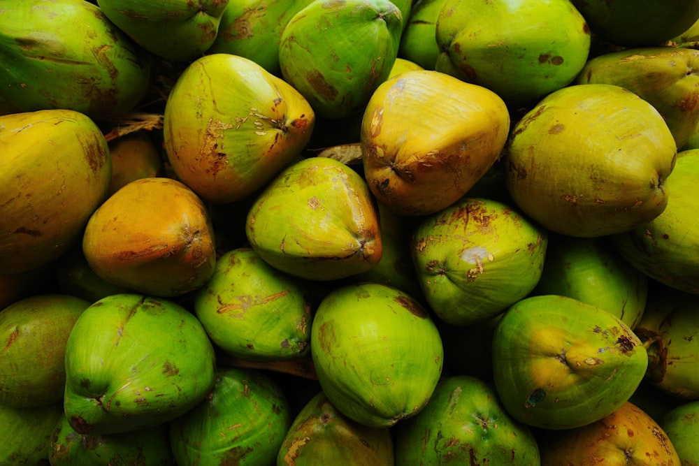 a pile of green coconuts sitting on top of each other