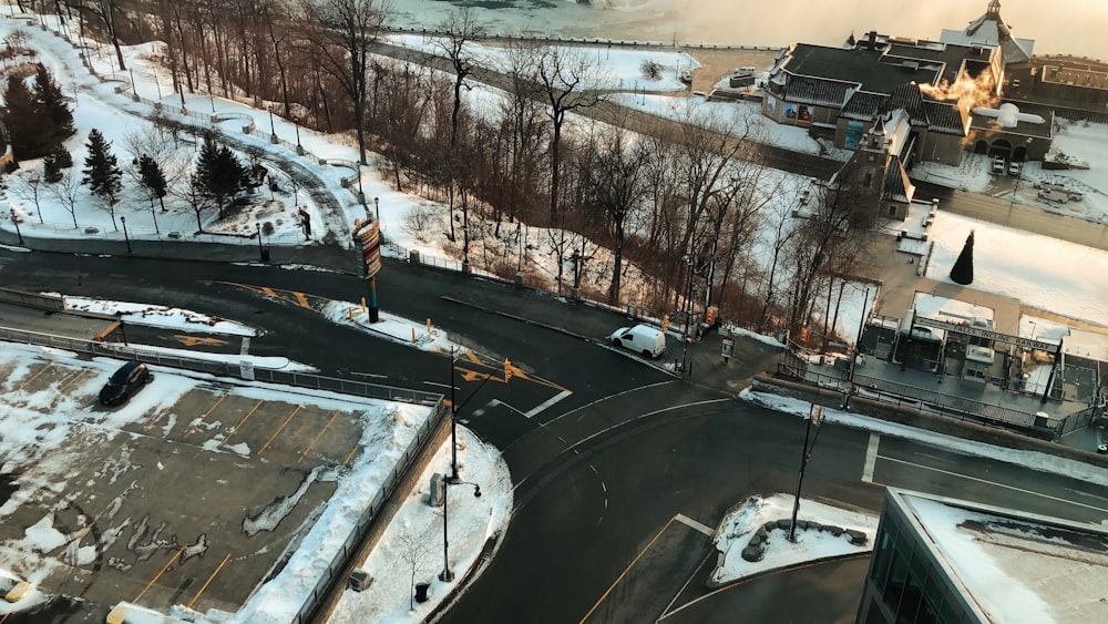 an aerial view of a street and a parking lot covered in snow