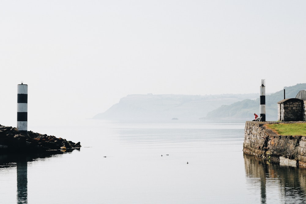 a body of water with a light house in the distance