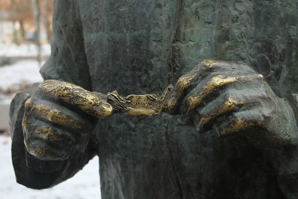 eine Statue eines Mannes, der einen Frosch in den Händen hält