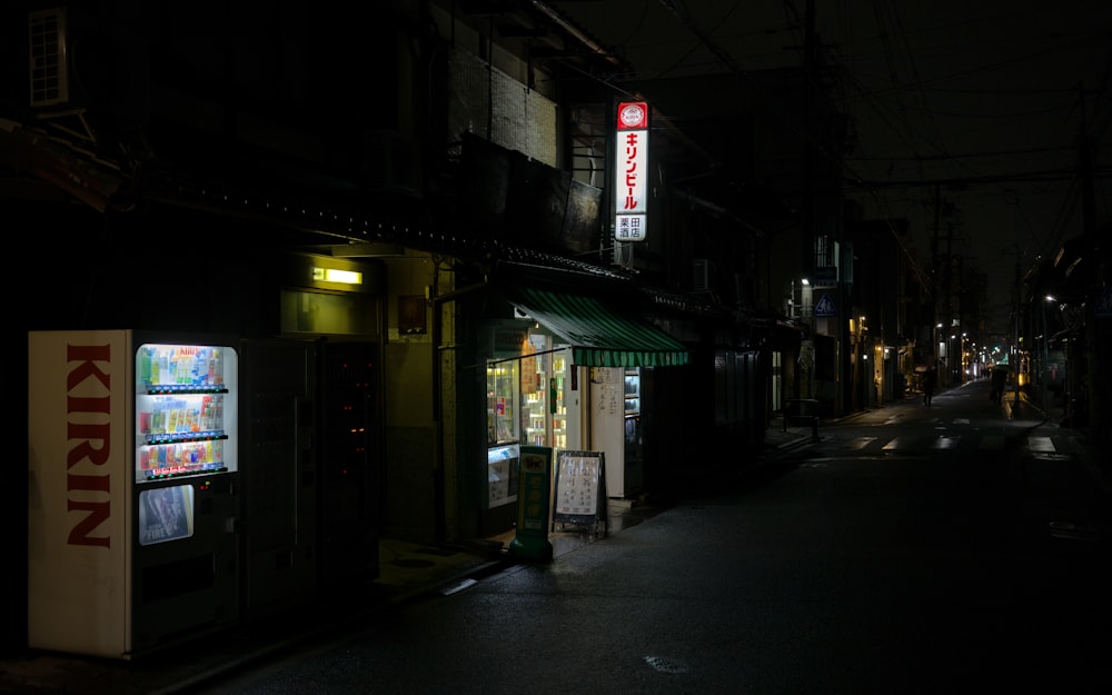 Uma rua escura da cidade à noite com uma máquina de venda automática