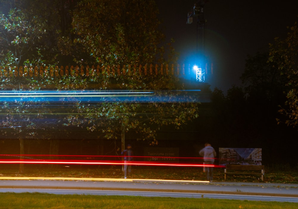 a couple of people sitting on a bench at night