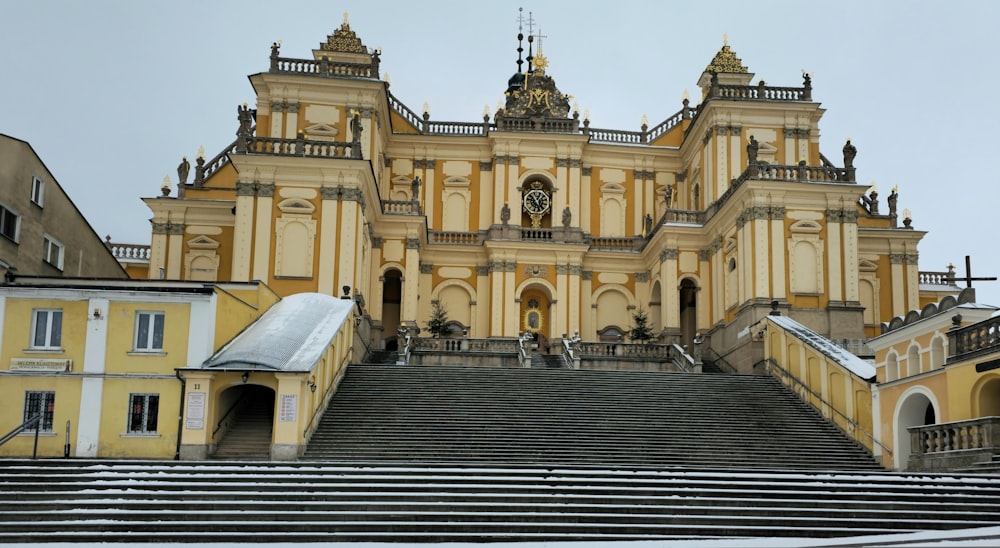 a large yellow building with stairs leading up to it