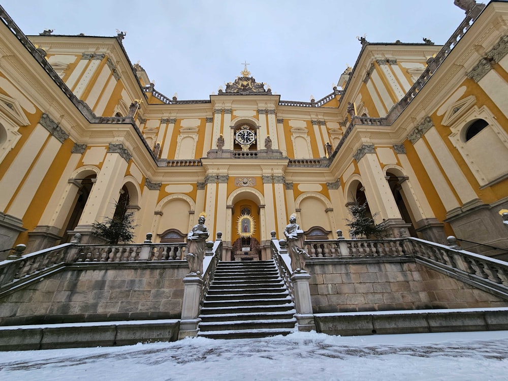 a large yellow building with stairs leading up to it