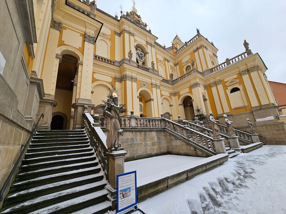 a large building with stairs and a sign in front of it