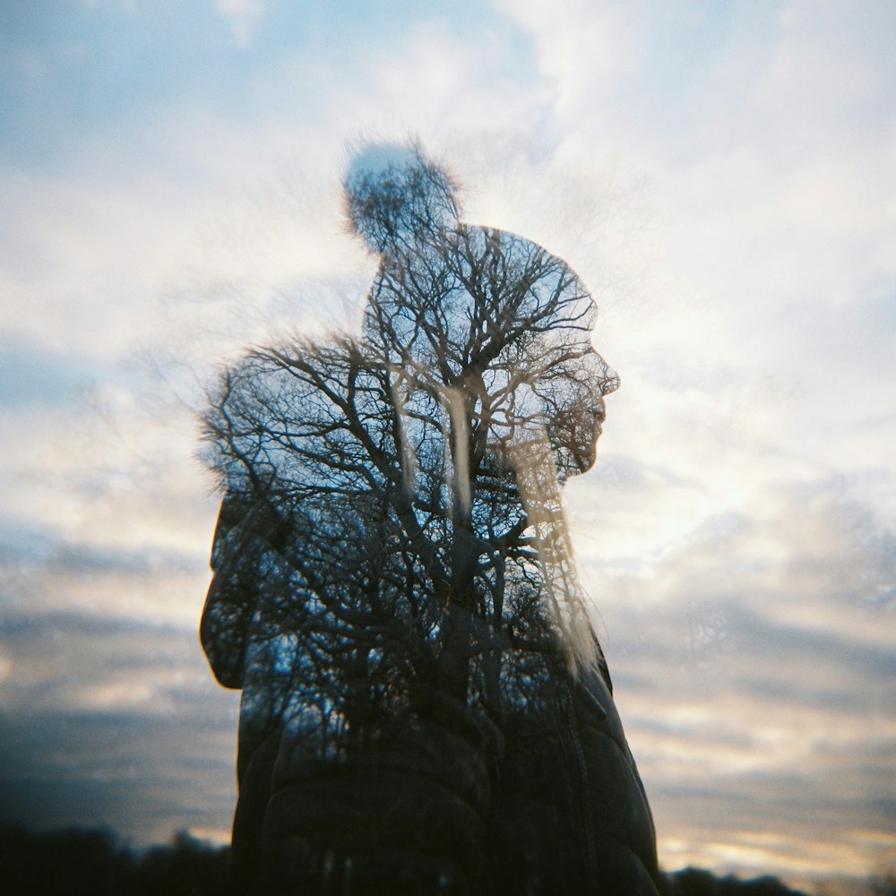 a reflection of a person with trees in the background