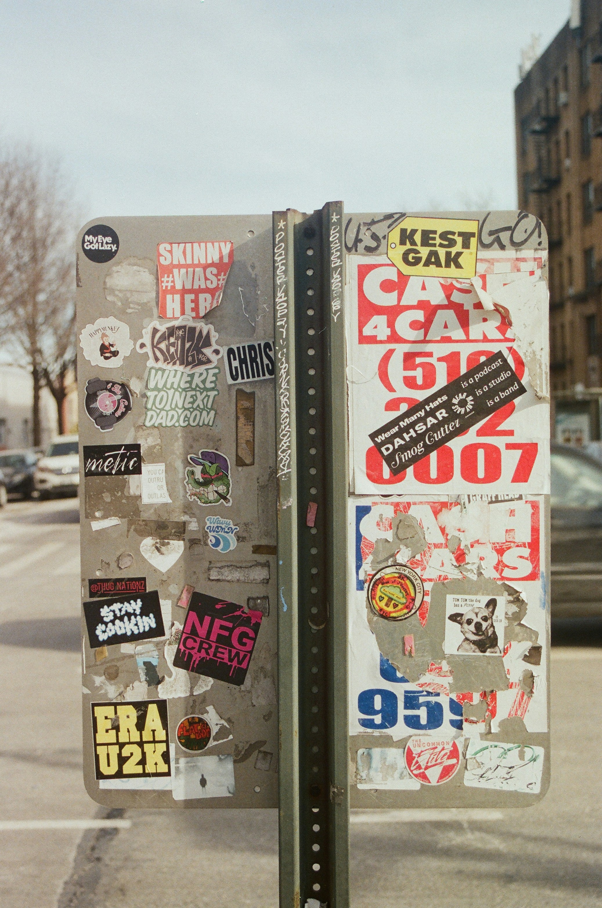 a parking meter covered in stickers on a city street